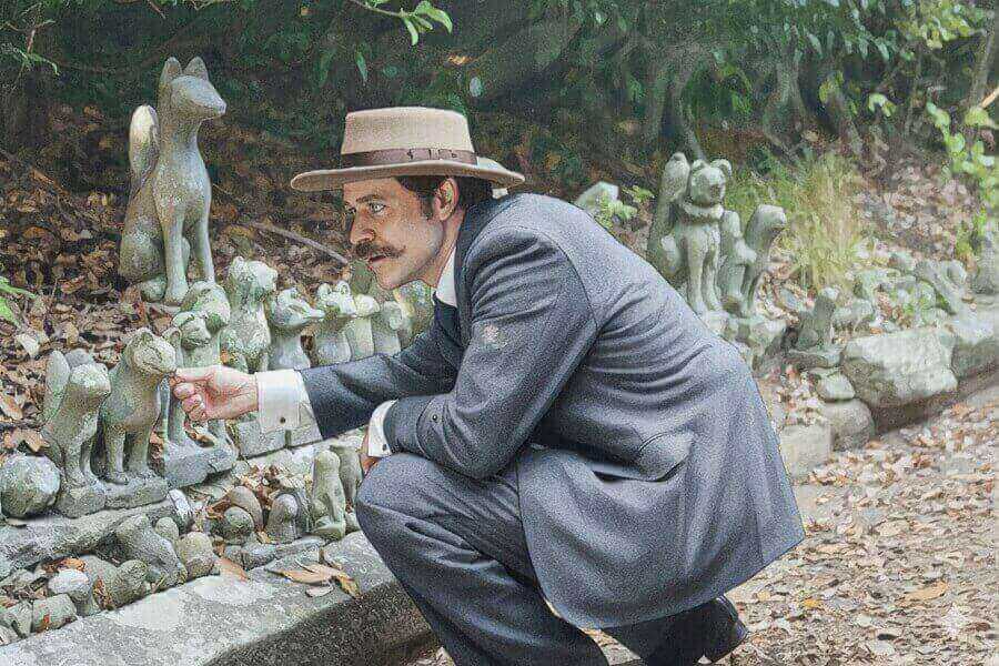 狐の像に興味をもつヘブンのイラスト